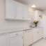 Kitchen remodel with painted white cabinets, quartz countertops, stainless steel sink, and classic subway tile backsplash.